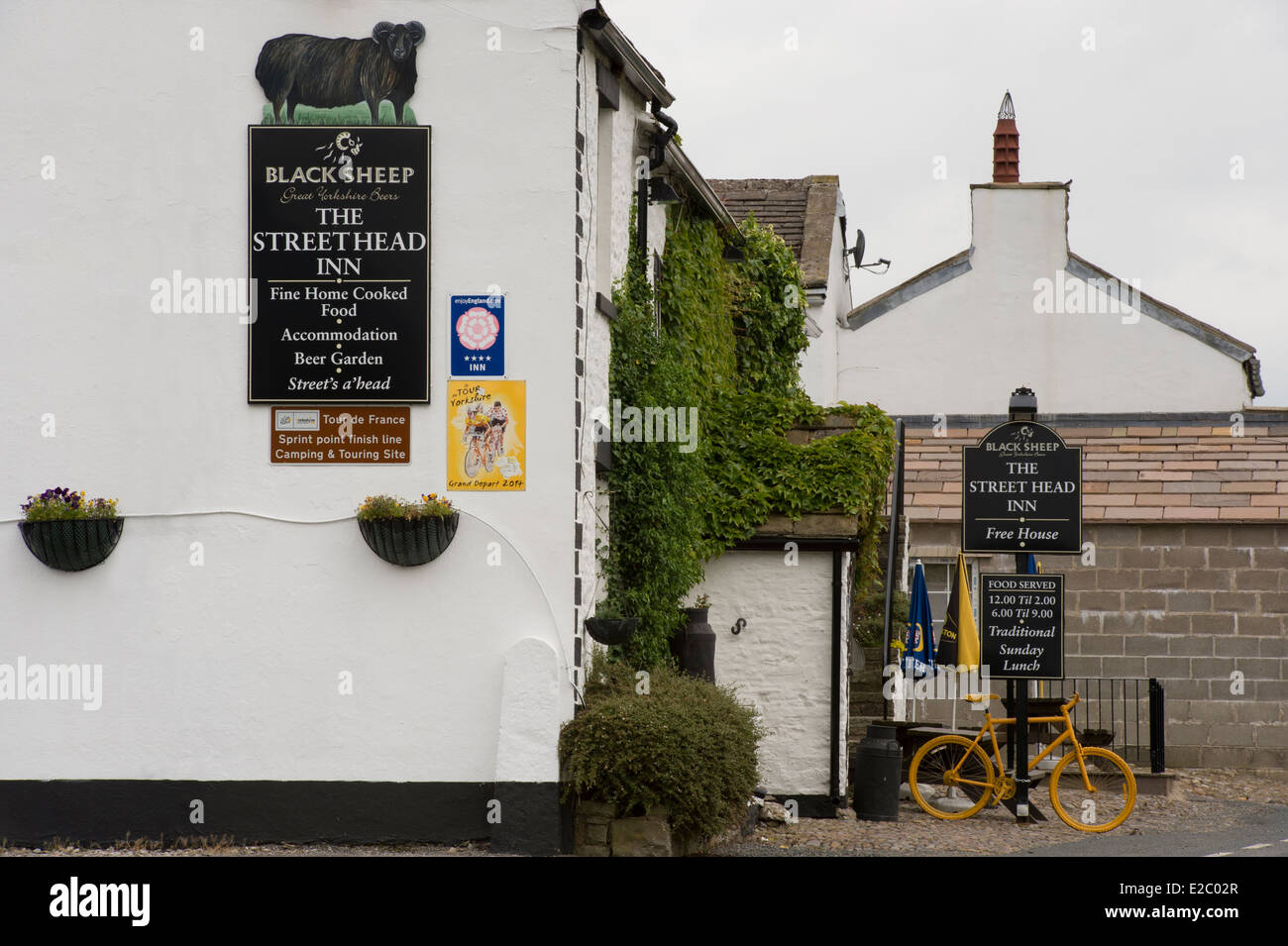 Partial exterior view of The Street Head Inn & its signs, a whitewashed traditional English, country pub - Newbiggin, North Yorkshire, England, UK. Stock Photo