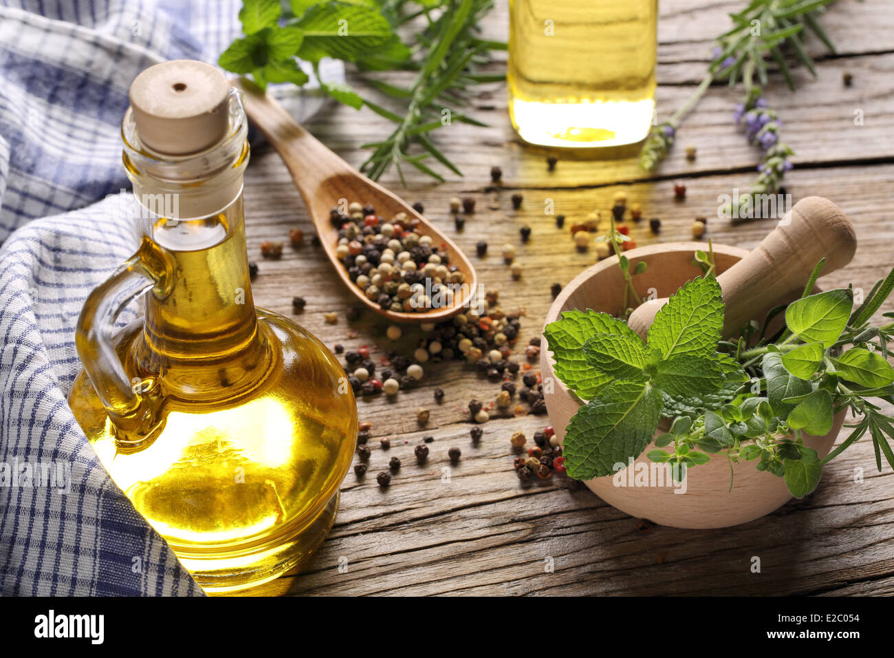 herbs and oil on wooden table Stock Photo