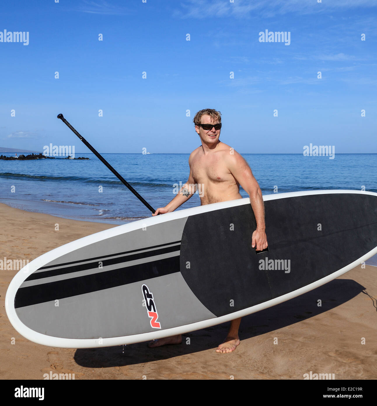 Man with stand up paddle board at Wailea Beach on Maui Stock Photo
