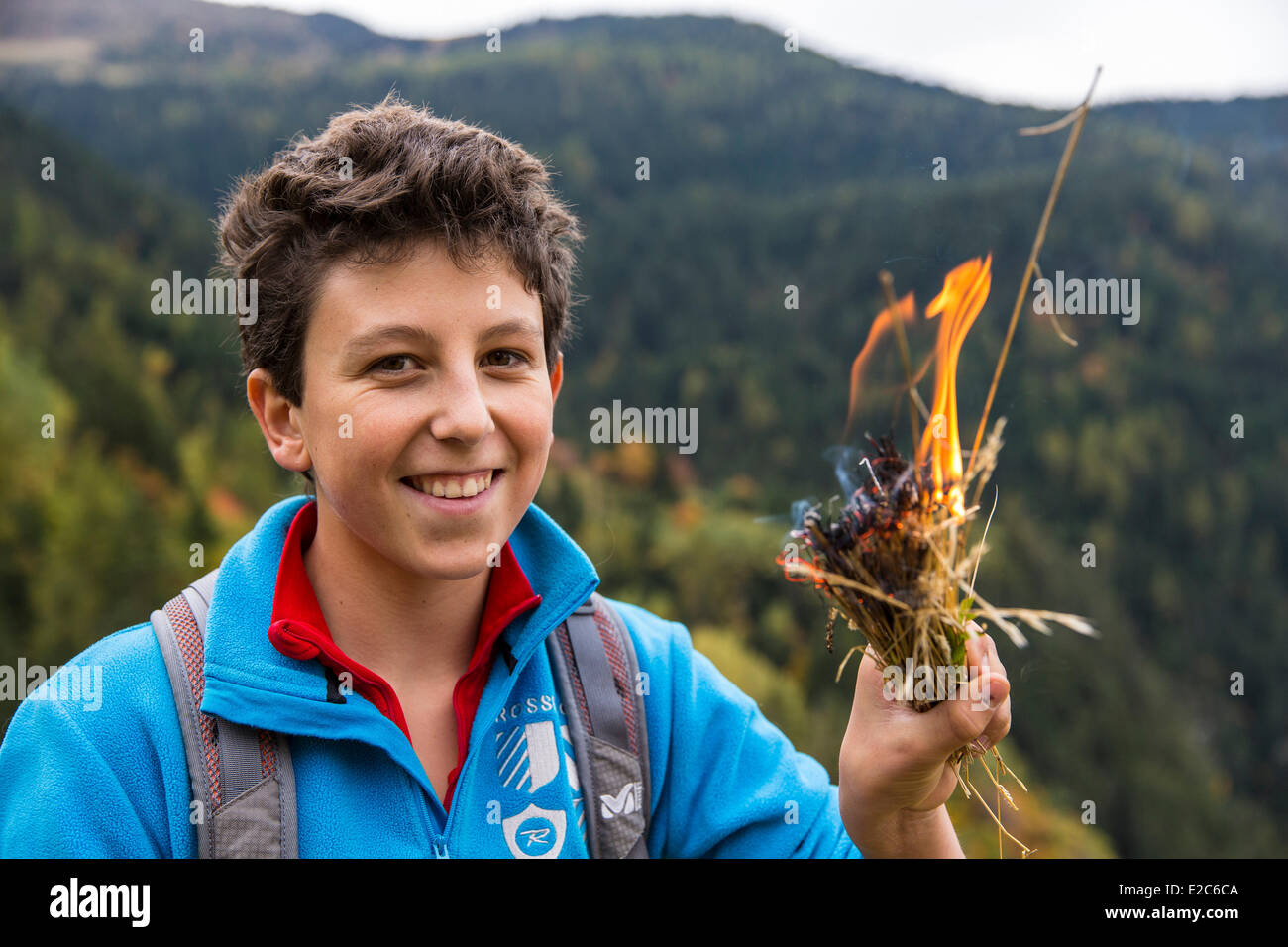 France, Savoie, Notre Dame du Pre, adolescent playing with the fire Stock Photo