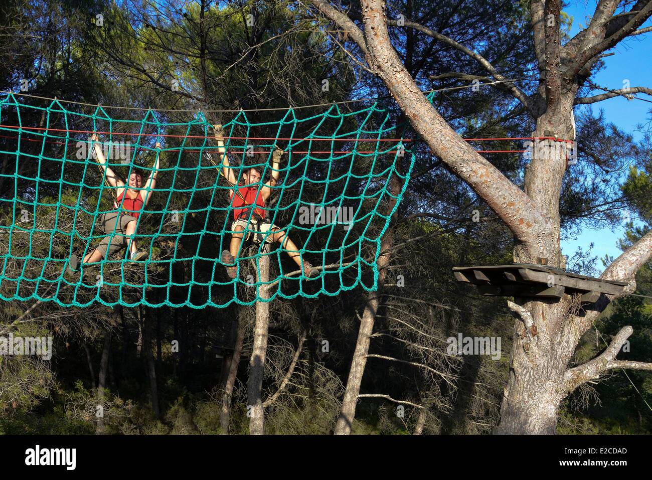 France, Herault, Beziers, Wood of Bourbaki, park of adventure in forest consisted of Tyrolean and of climbing walls, couple suspended from a net in rope above the space Stock Photo