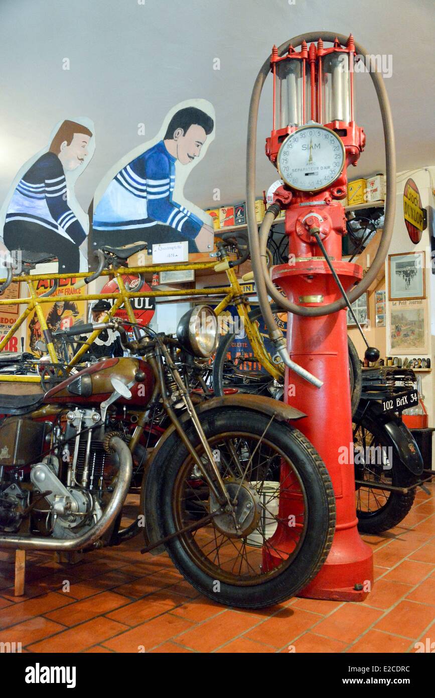France, Herault, Boujan sur Libron, Chapy museum, exhibition of former motorcycles in the middle of posters of time, old gas pump with crank Stock Photo