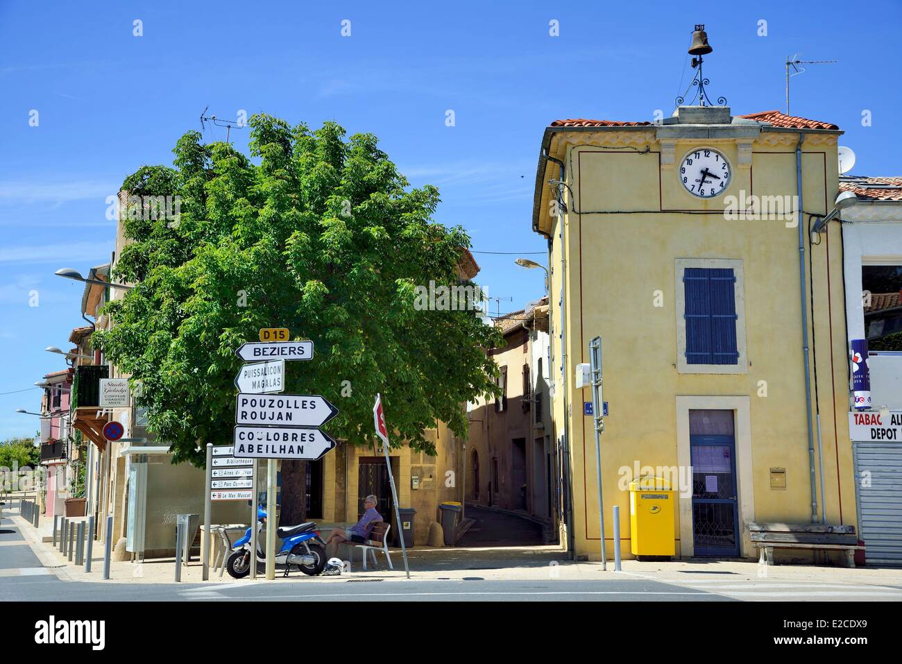 France, Herault, Espondeilhan, road of Beziers, man sat on a bench in the shade of a tree along a road which crosses a village Stock Photo