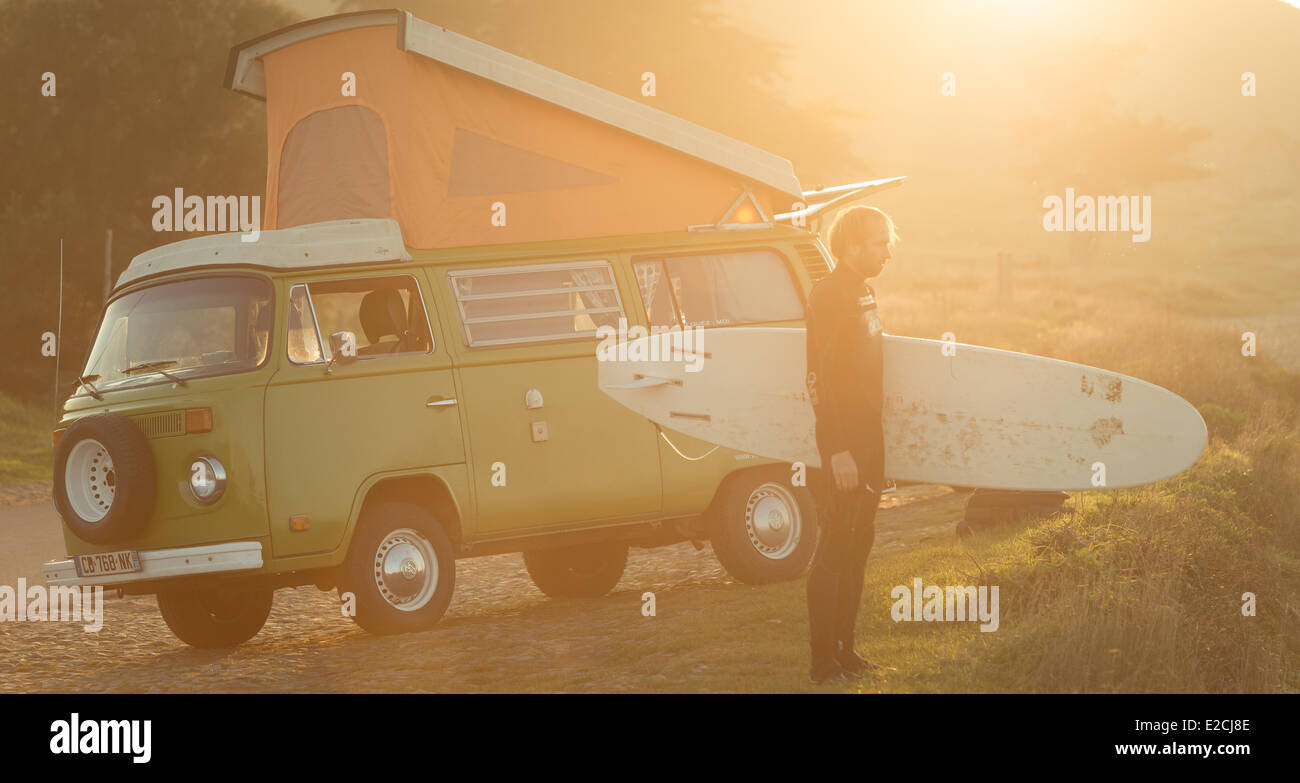France, Cotes d'Armor, Erquy, Volkswagen combi 1976 and surfer on the beach in St. Pabu Stock Photo