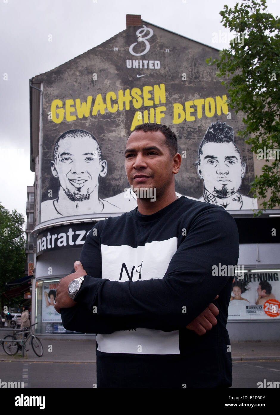 Berlin, Germany. 19th June, 2014. George Boateng poses in front of a graffiti with the lettering 'grown on concrete' which shows himself and his brothers Jerome and Kevin-Prince in Berlin, Germany, 19 June 2014. Photo: DANIEL NAUPOLD/DPA/Alamy Live News Stock Photo