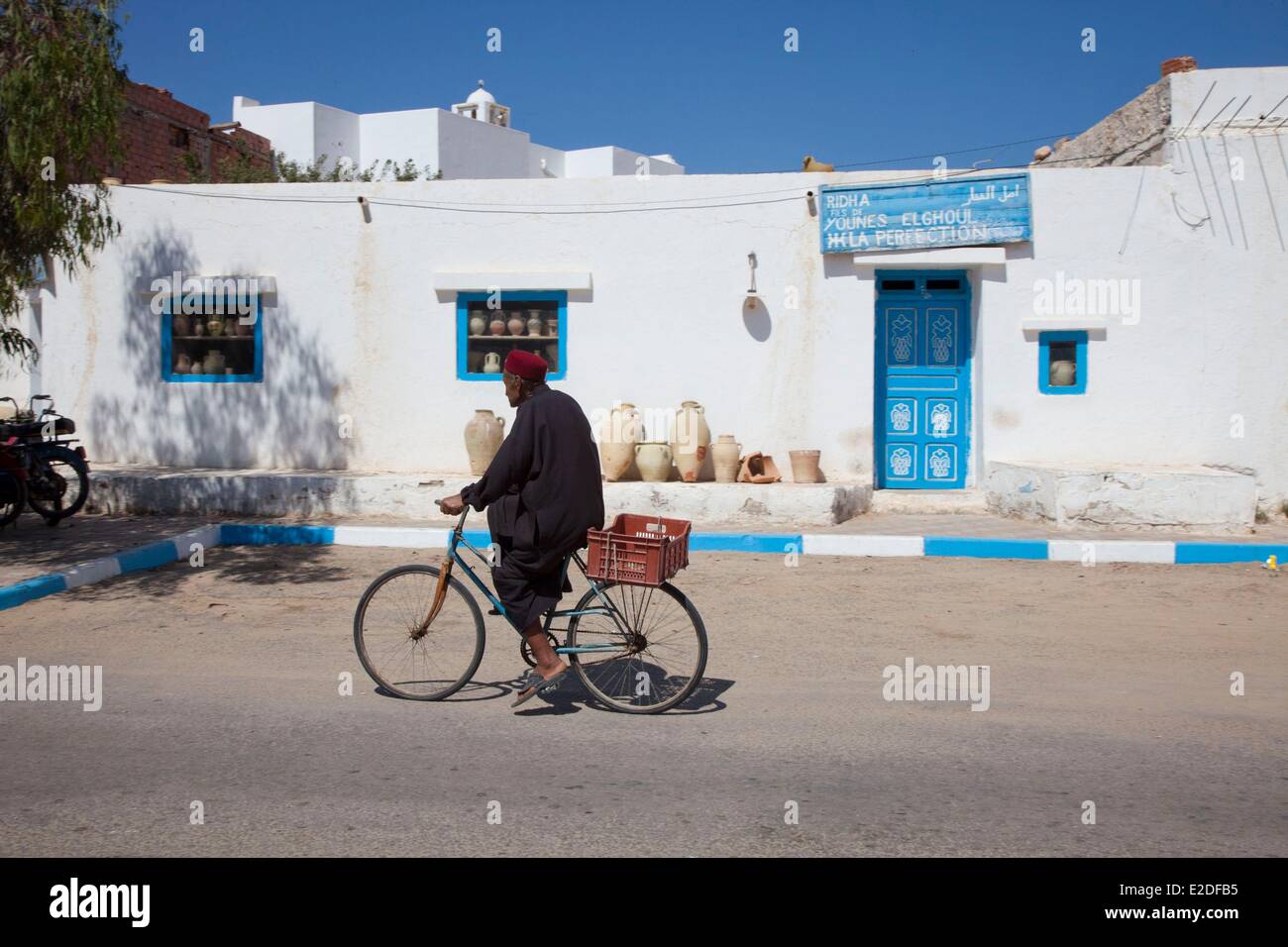 Tunisia, Jerba, Guellala village, Tunisian cycling in front of a pottery shop Stock Photo