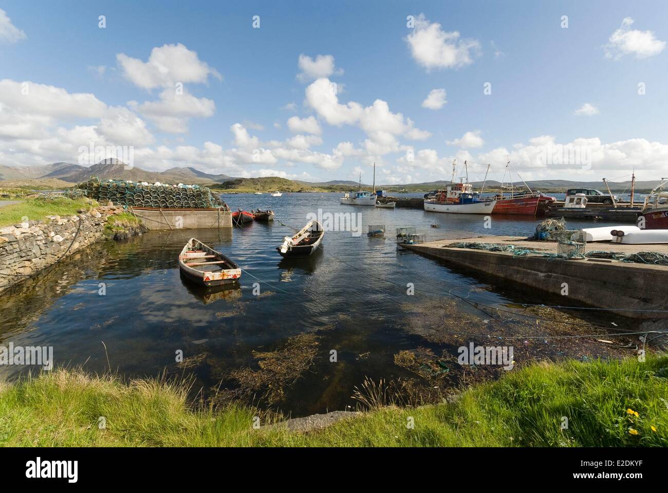 Ireland Galway County Ballynakill Connemara wooden boats and fishing boats in the harbor Tully and Twelve Bens mountains in the Stock Photo