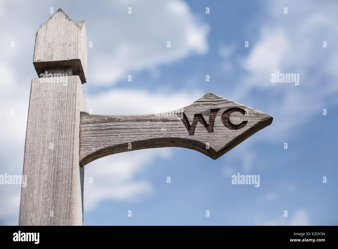Old wooden signpost over blue sky background. Stock Photo