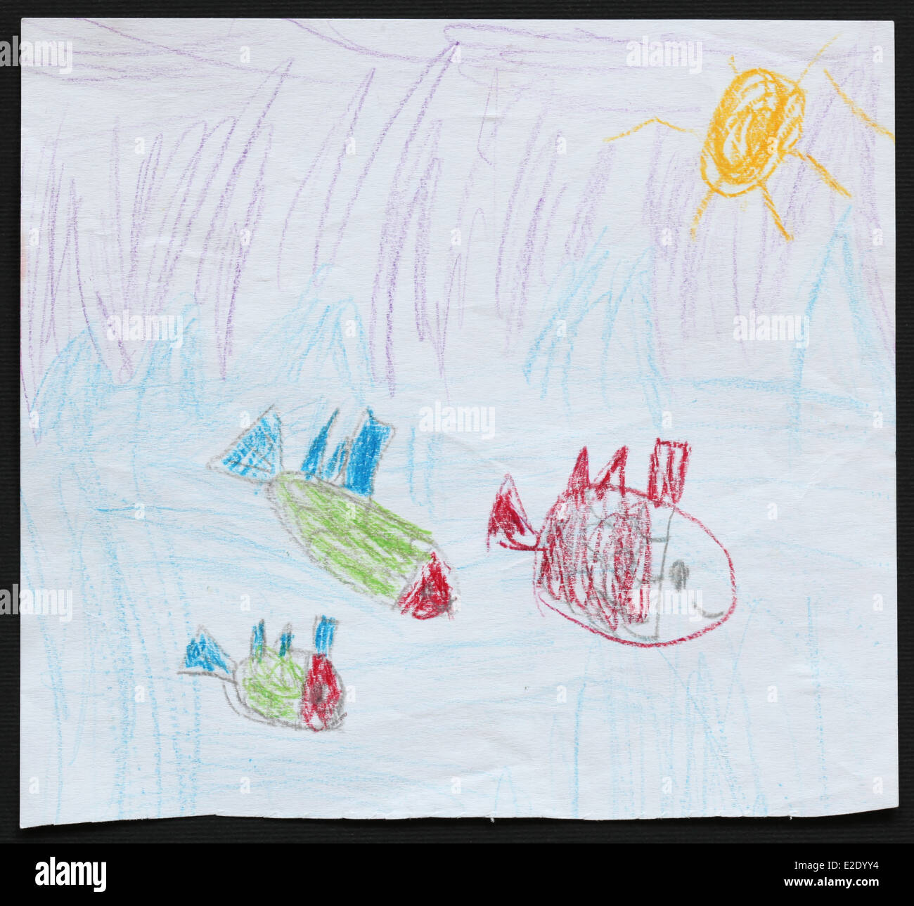 Original child's drawing of three fishes in a blue sea drawn by a five-year-old girl. Stock Photo