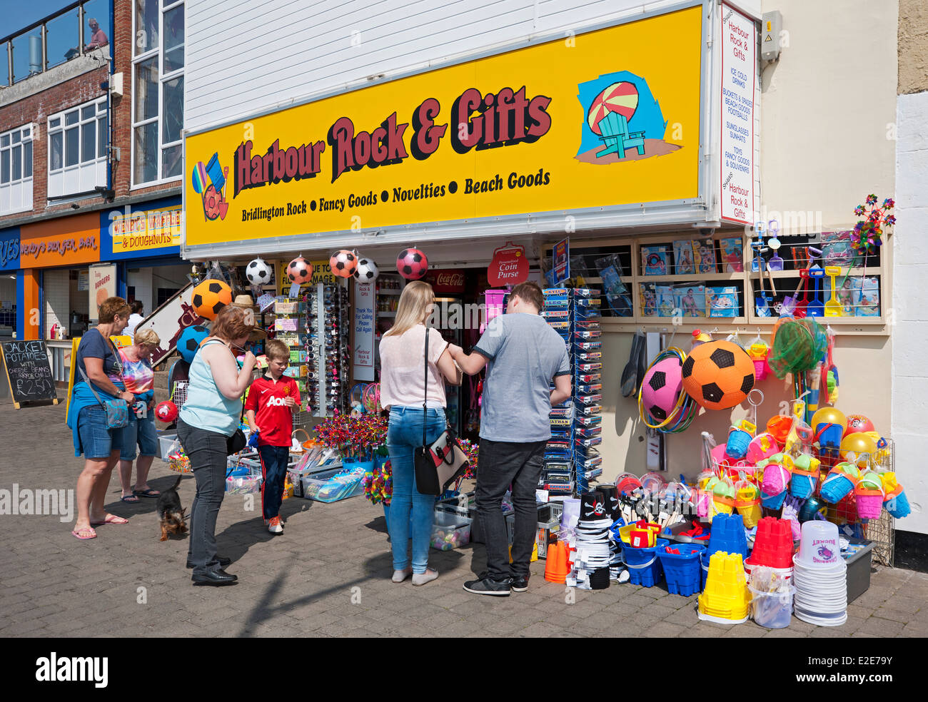People tourists visitors looking at store Shop Selling Beach Goods on the Seafront in summer Bridlington East Yorkshire England UK United Kingdom Stock Photo