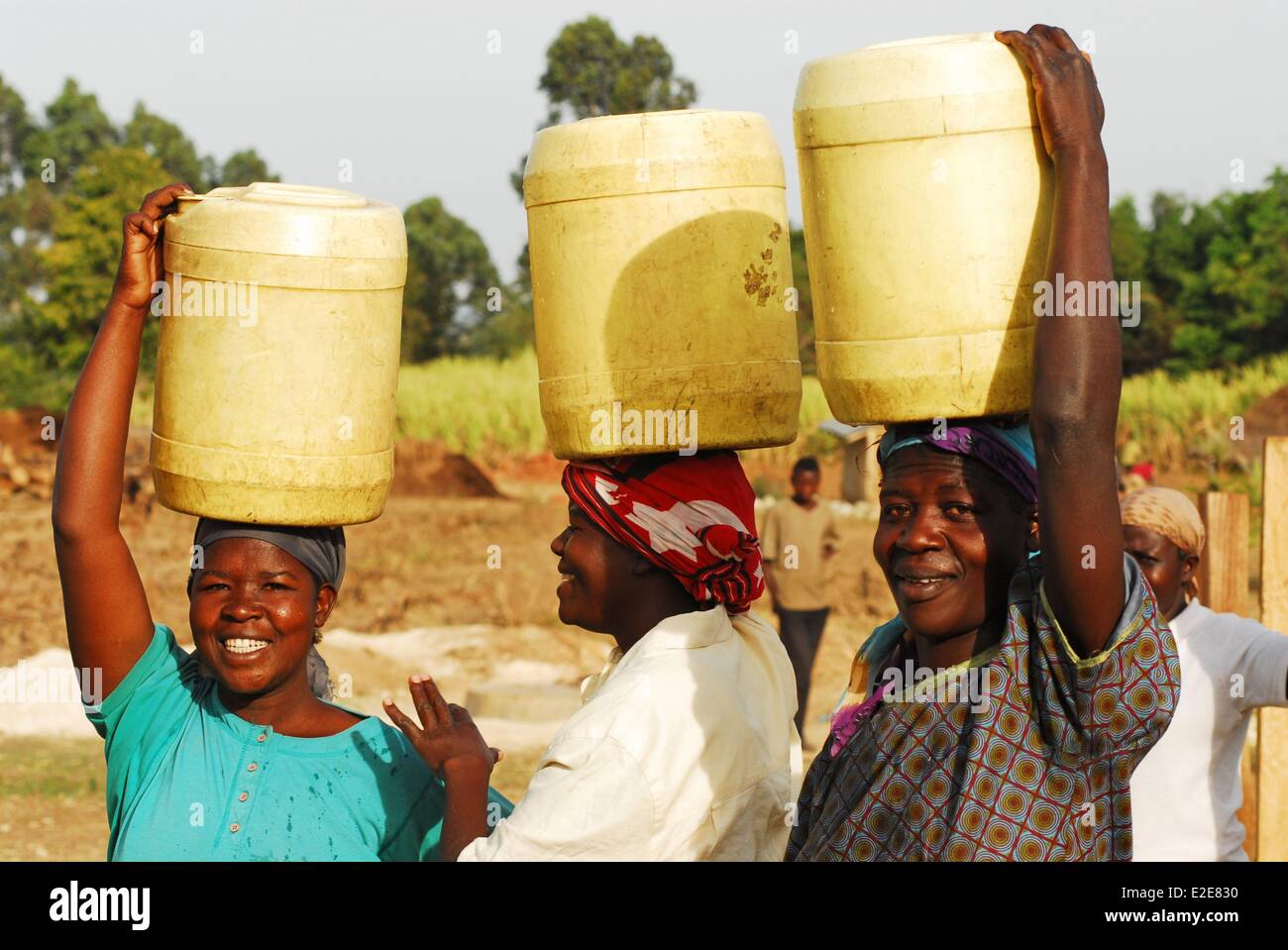 Kenya, Kakamega, three women carrying water containeron top of their ...