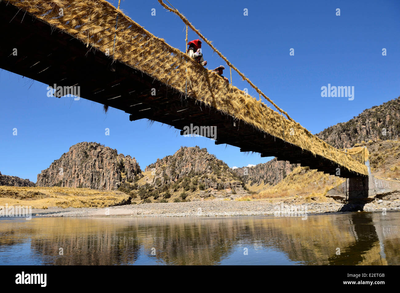 Peru Espinar province Suykutambo Tree Canyons Peruvian couple in traditional dress on a rope bridge spanning the Rio Apurimac Stock Photo