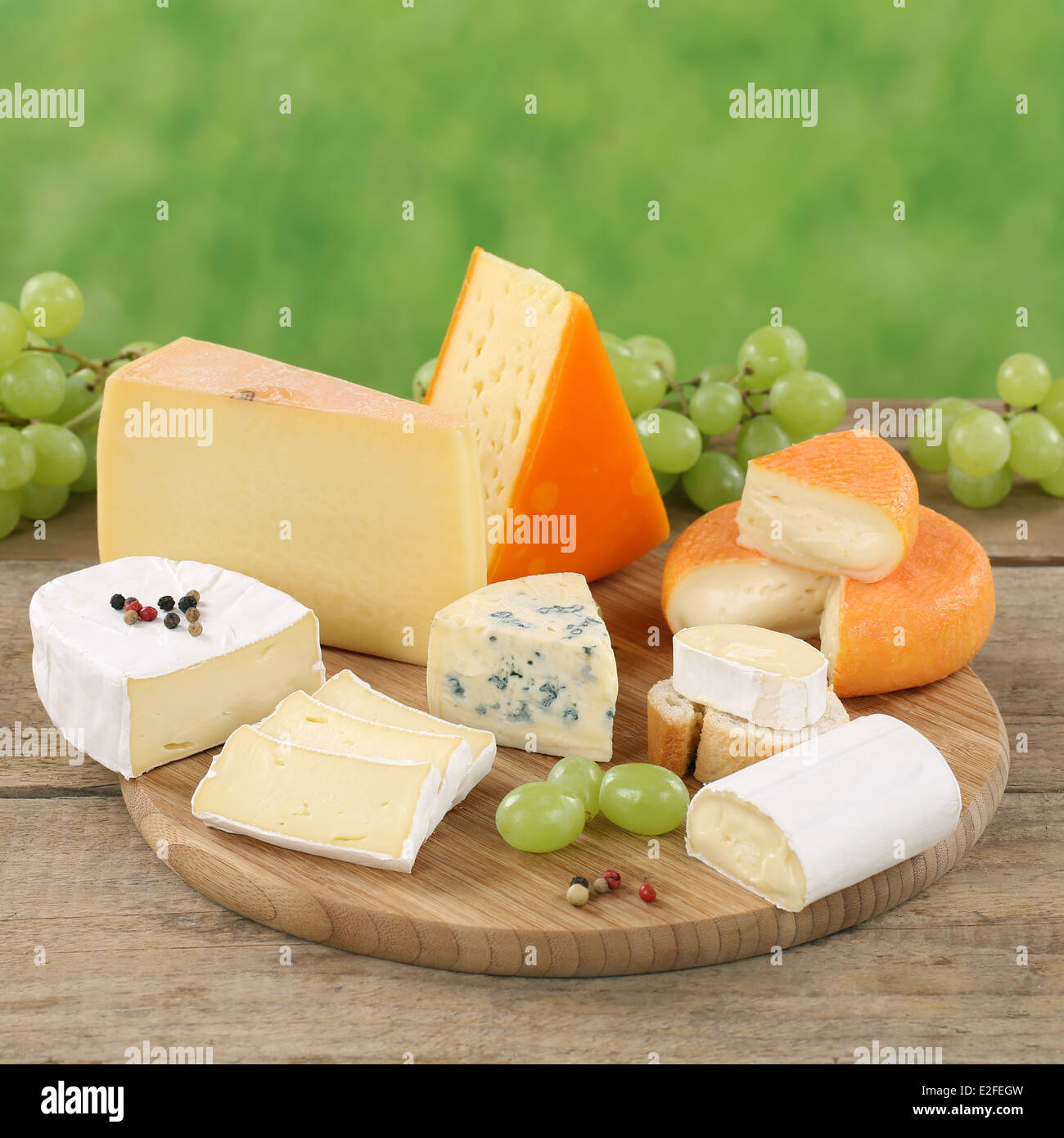 Plate with Camembert, Gouda, mountain and Swiss cheese on a wooden board Stock Photo