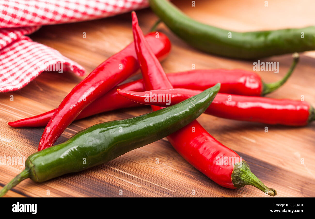 Image shows red and green chili pepper on wooden plate Stock Photo - Alamy