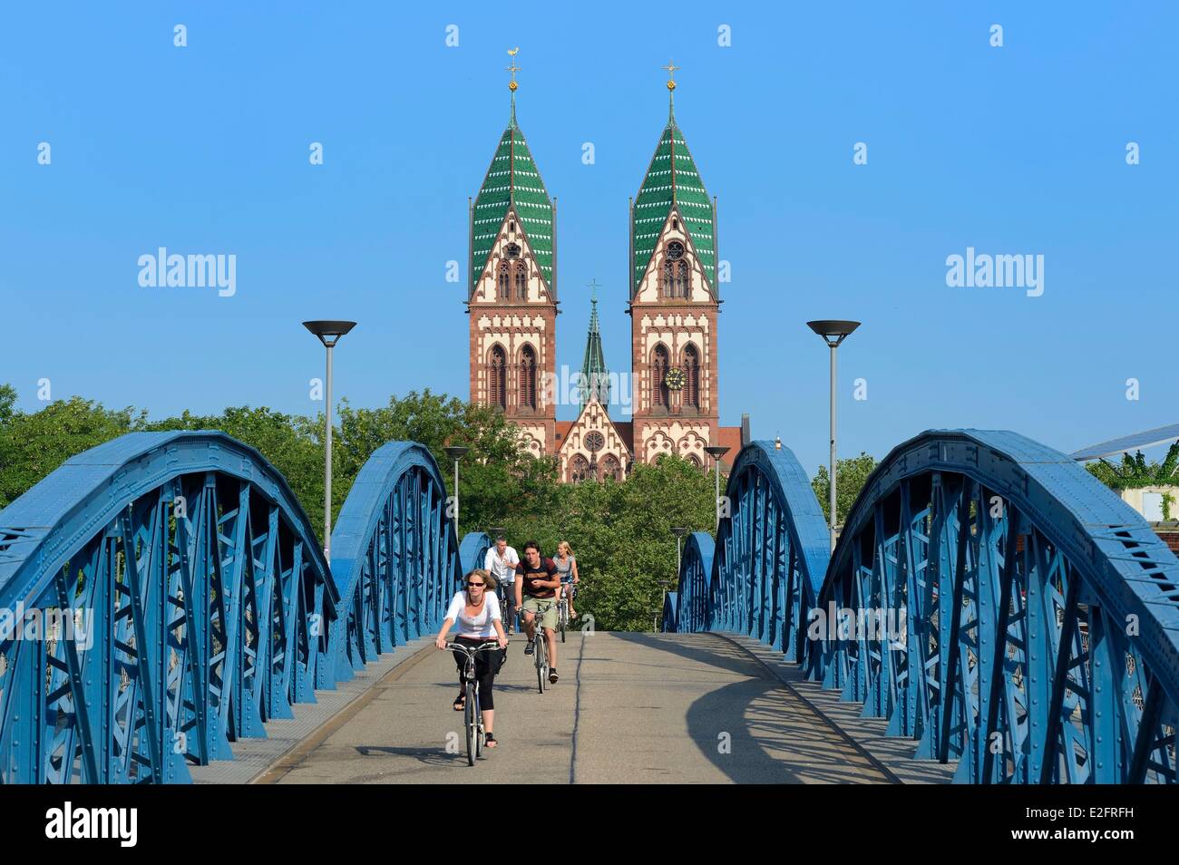 Germany Baden Wurttemberg Freiburg im Breisgau cyclist on the blue bridge (wiwili bridge) and the Sacred Heart of Jesus Church Stock Photo