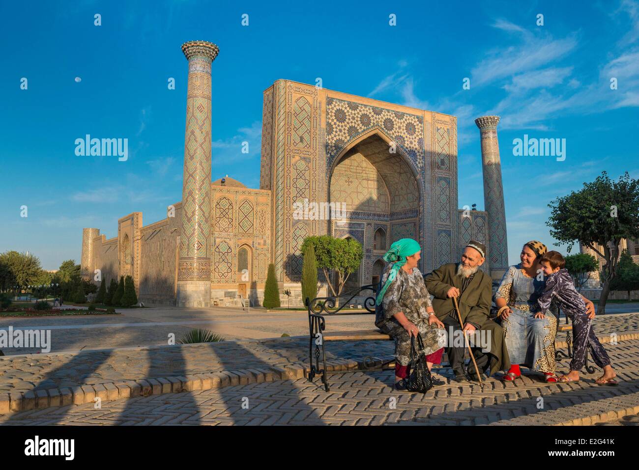 Uzbekistan Silk Road Samarkand listed as World Heritage by UNESCO Registan place Ferghana valley pilgrims in front of the Ulugh Stock Photo