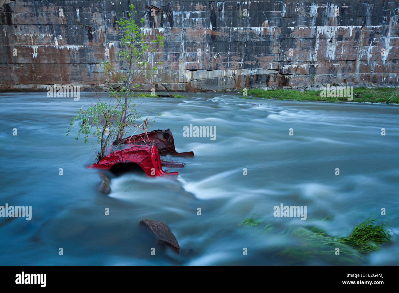 Remains of a red car in the Holland River. Rogers Reservoir, East Gwillimbury, Ontario, Canada. Stock Photo