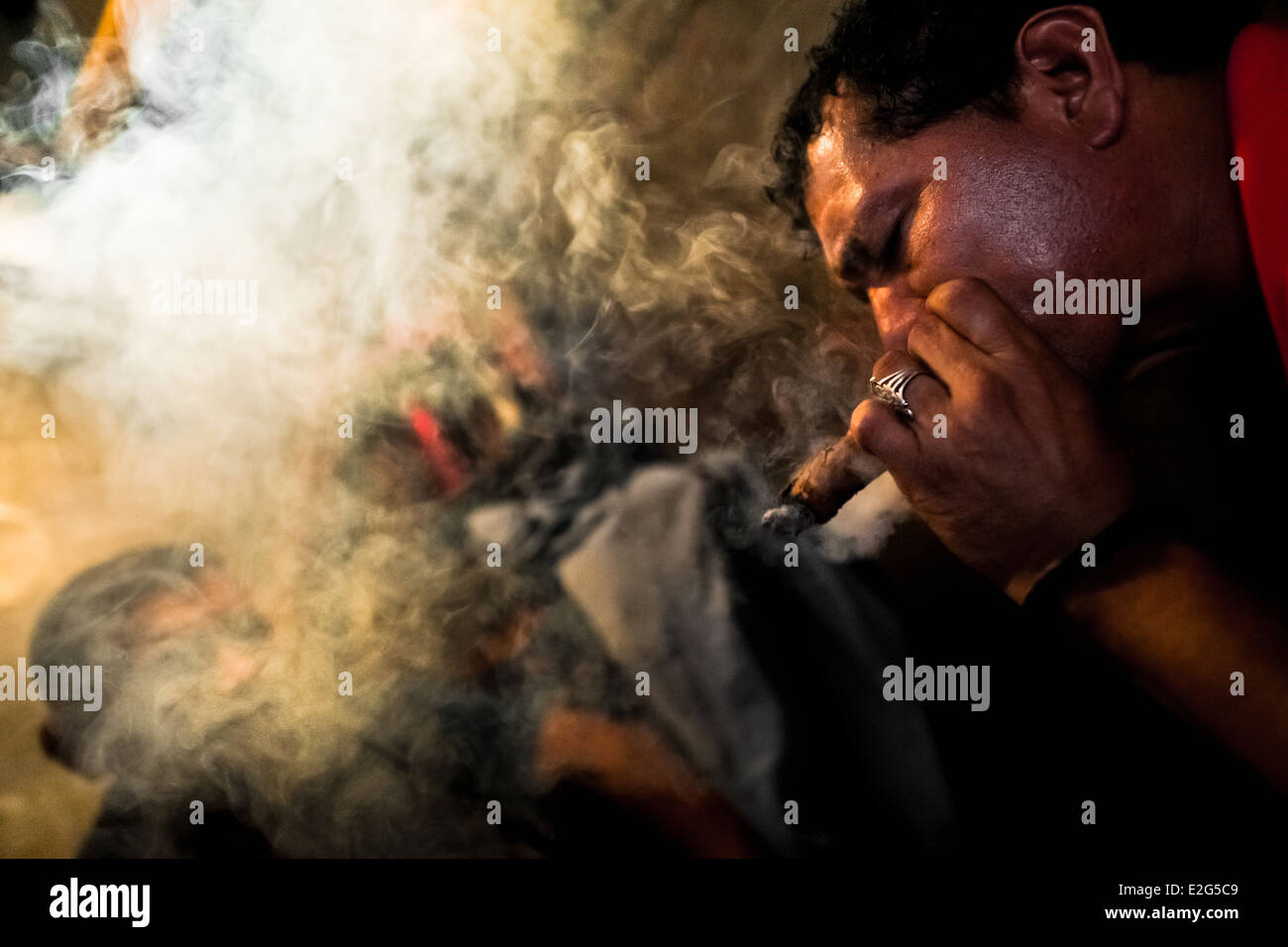 burning tobacco leaves A Salvadorean 'brujo' (sorcerer) predicts the future from burn tobacco  leaves in a street fortune telling shop in San Salvador Stock Photo
