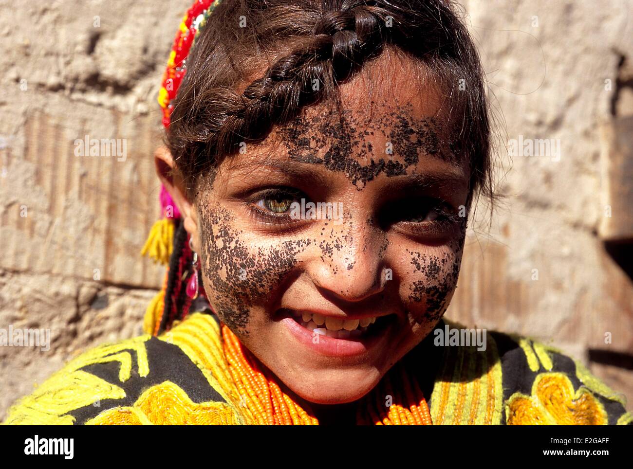 Pakistan Khyber Pakhtunkhwa Kalash valleys Bumburet valley little Kalash girl protecting her face from the cold by a mask made Stock Photo