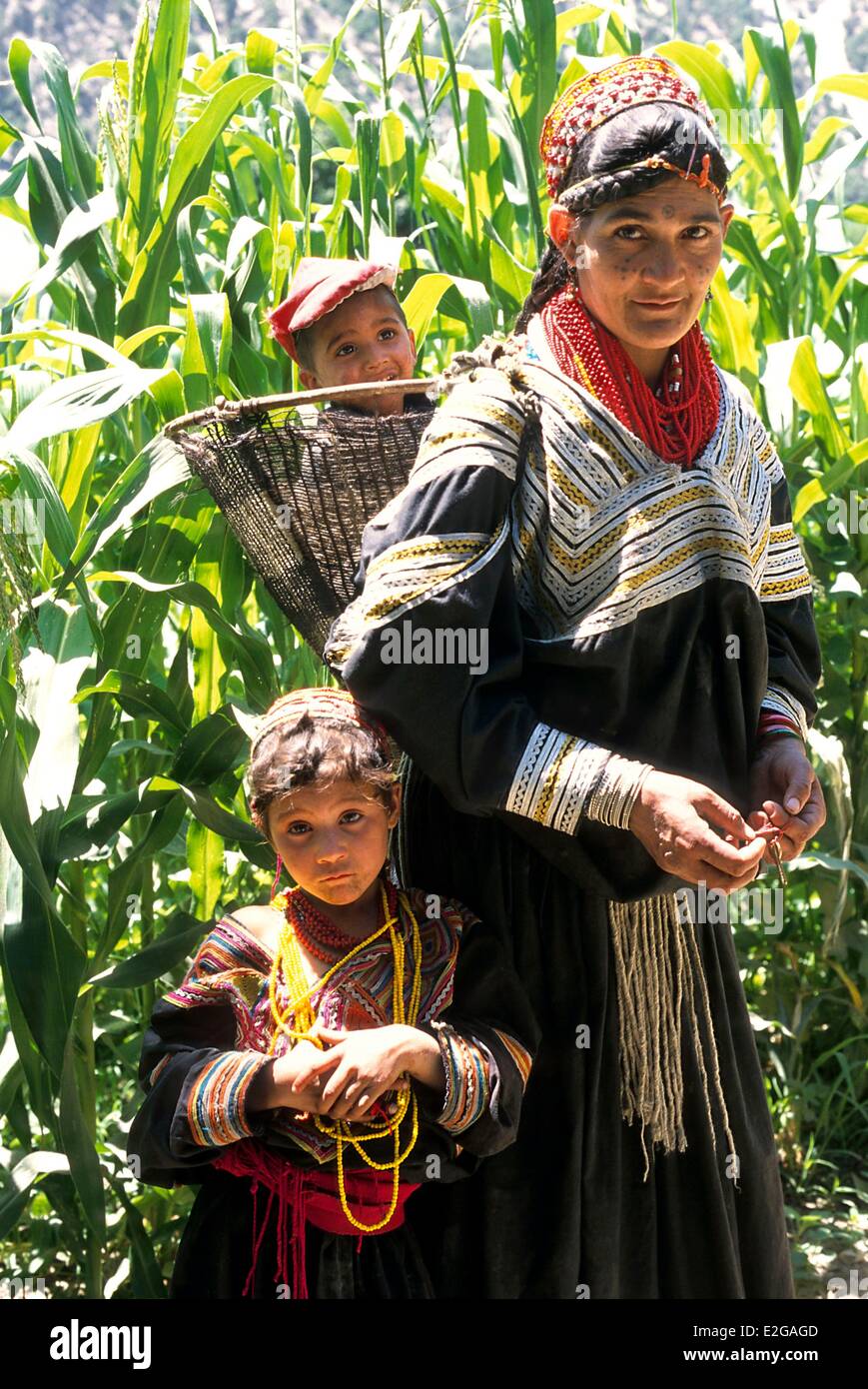 Pakistan Khyber Pakhtunkhwa Kalash valleys Bumburet valley Kalash woman carrying her youngest child in her Kawa traditional Stock Photo