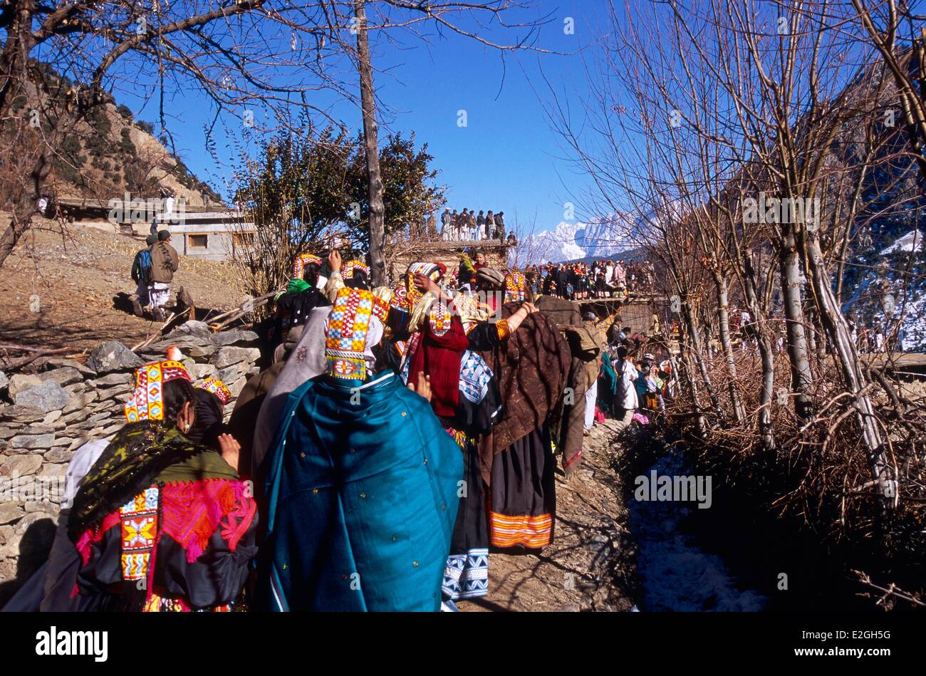 Pakistan Khyber Pakhtunkhwa Kalash valleys Bumburet valley Krakal village (2150m) in procession group of girls join group of boys already on flat roofs for Savalik Harik ritual day of provocations celebrations of Chaumos winter solstice festival Stock Photo