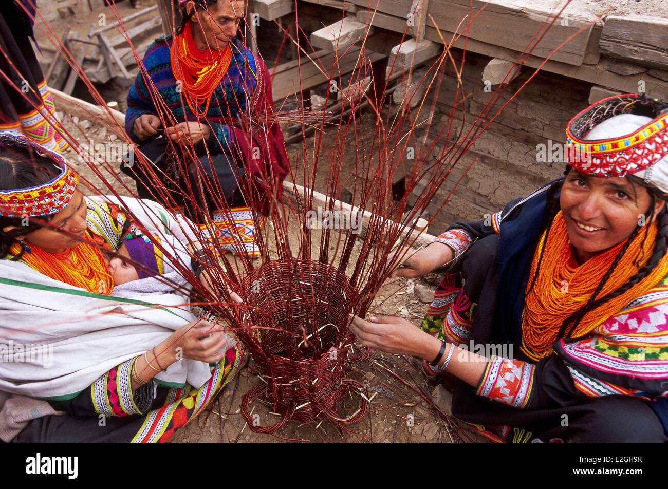 Pakistan Khyber Pakhtunkhwa Kalash valleys Bumburet valley Kalash women making a Graouni large wicker basket that will contain all requests Kalash before being offered to flames of sacred fire lit for Balumein prestigious Kalash god visiting them as in ce Stock Photo