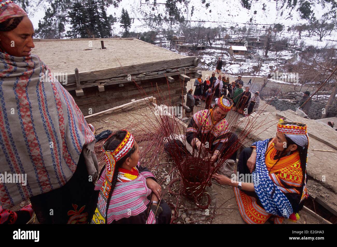 Pakistan Khyber Pakhtunkhwa Kalash valleys Bumburet valley Krakal village (2150m) Kalash women making a Graouni large wicker basket on flat roofs of houses offering only flat areas in this world of verticality Stock Photo