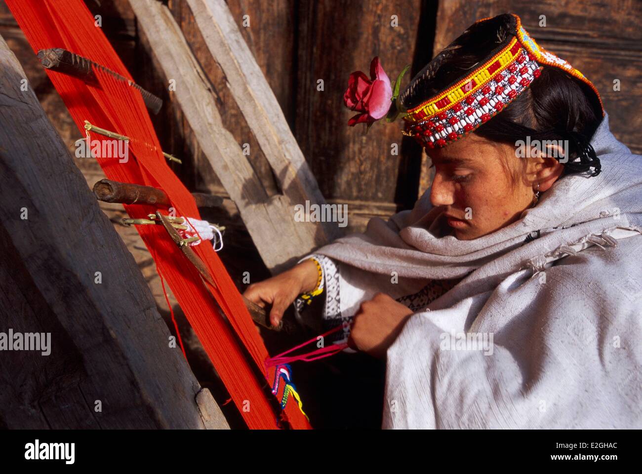 Pakistan Khyber Pakhtunkhwa Kalash valleys Bumburet valley Batrik village Kalash woman making up on her belt loom who help to maintain shape and adjust length of their dresses woollen band approximately 6 metres long Stock Photo