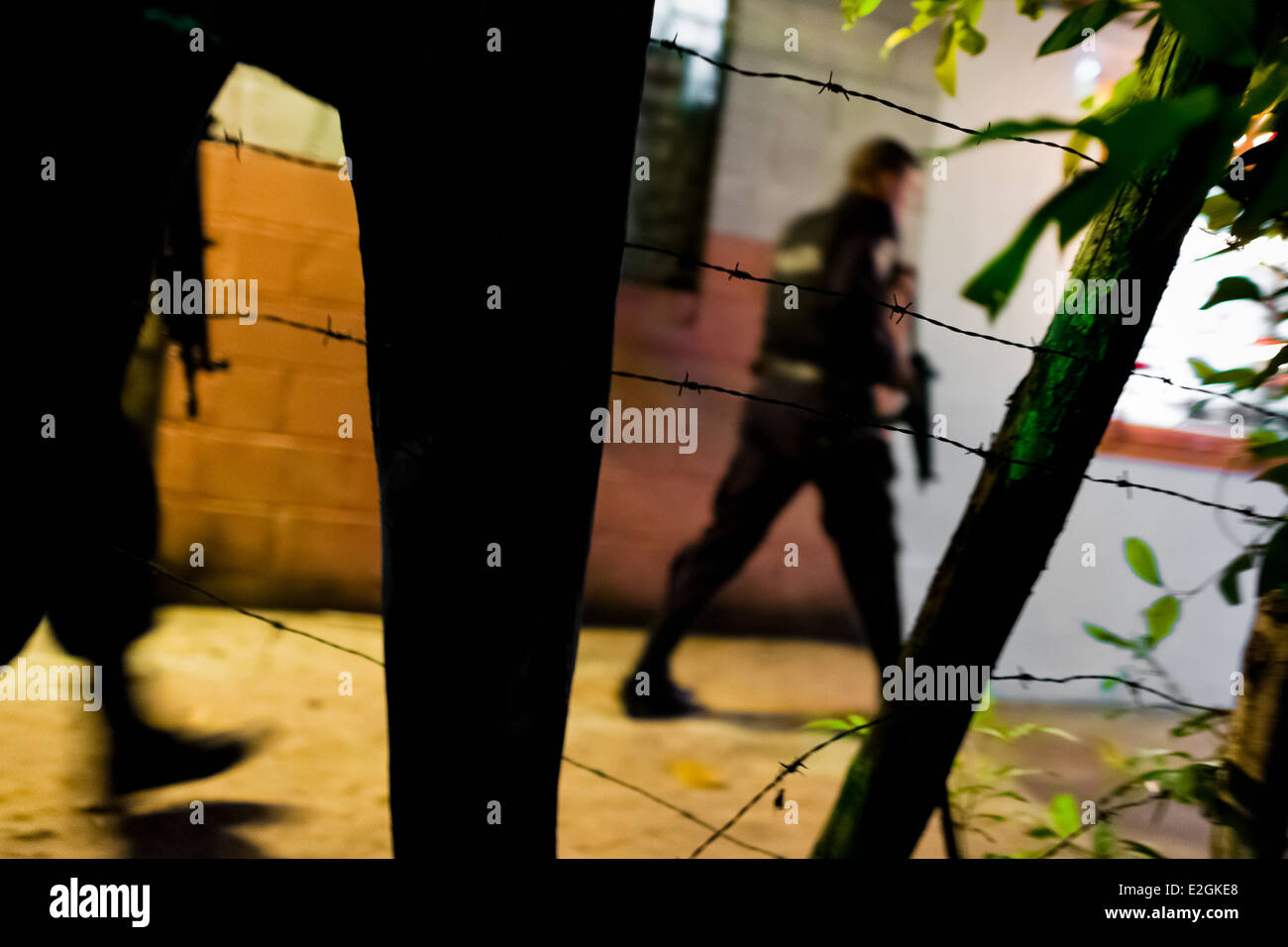 Policemen from the special emergency unit chase supposed gang members during the night in San Salvador, El Salvador. Stock Photo