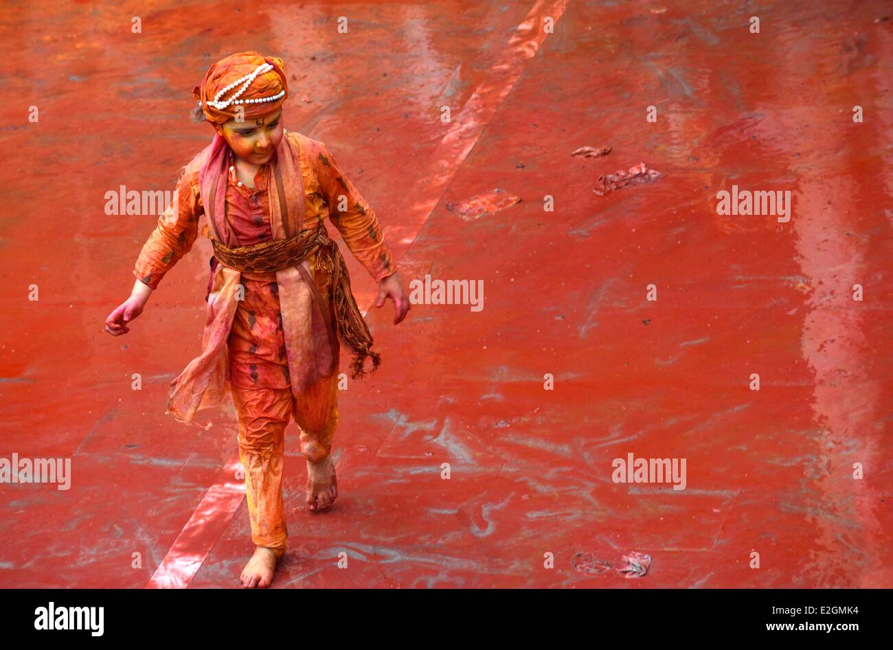 India Uttar Pradesh State in Barsana temple a child walks on ground full of coloured powder during Holi festival celebrations Stock Photo