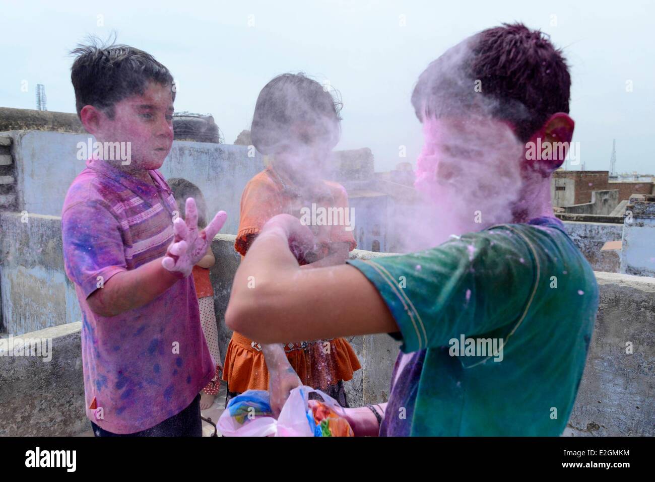 India Uttar Pradesh State Mathura young boys play with coloured powder during Holi festival celebrations Stock Photo