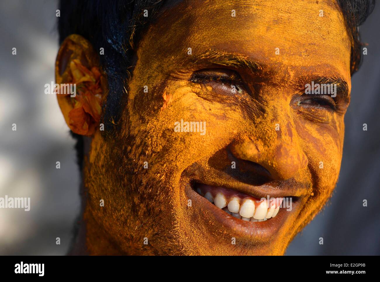India Uttar Pradesh State Mathura a young man makes up with coloured powder on his face during Holi festival celebrations Stock Photo
