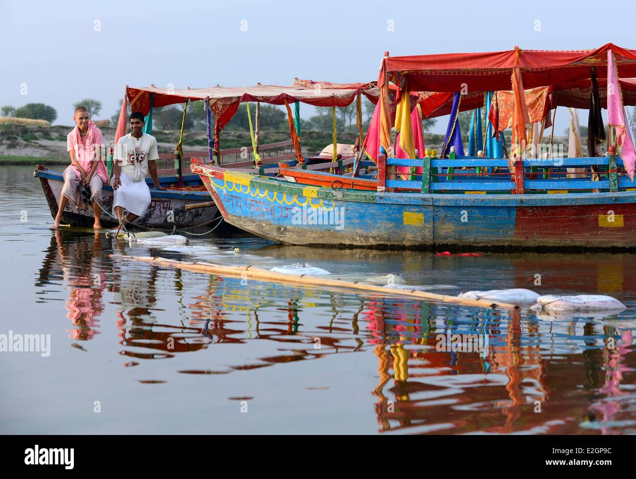India Uttar Pradesh State Mathura young woman and young man having rest on a boat across river during Holi festival celebrations Stock Photo