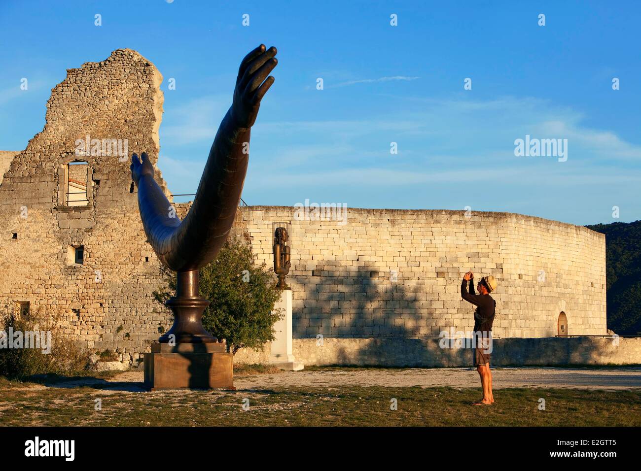 France Vaucluse Parc Naturel Regional du Luberon (Natural Regional Park of Luberon) Lacoste Lacoste castle ruins of 11th century one of residences of Marquis de Sade in 18th century sculpture Welcome by Alexander Bourganov in foreground Stock Photo