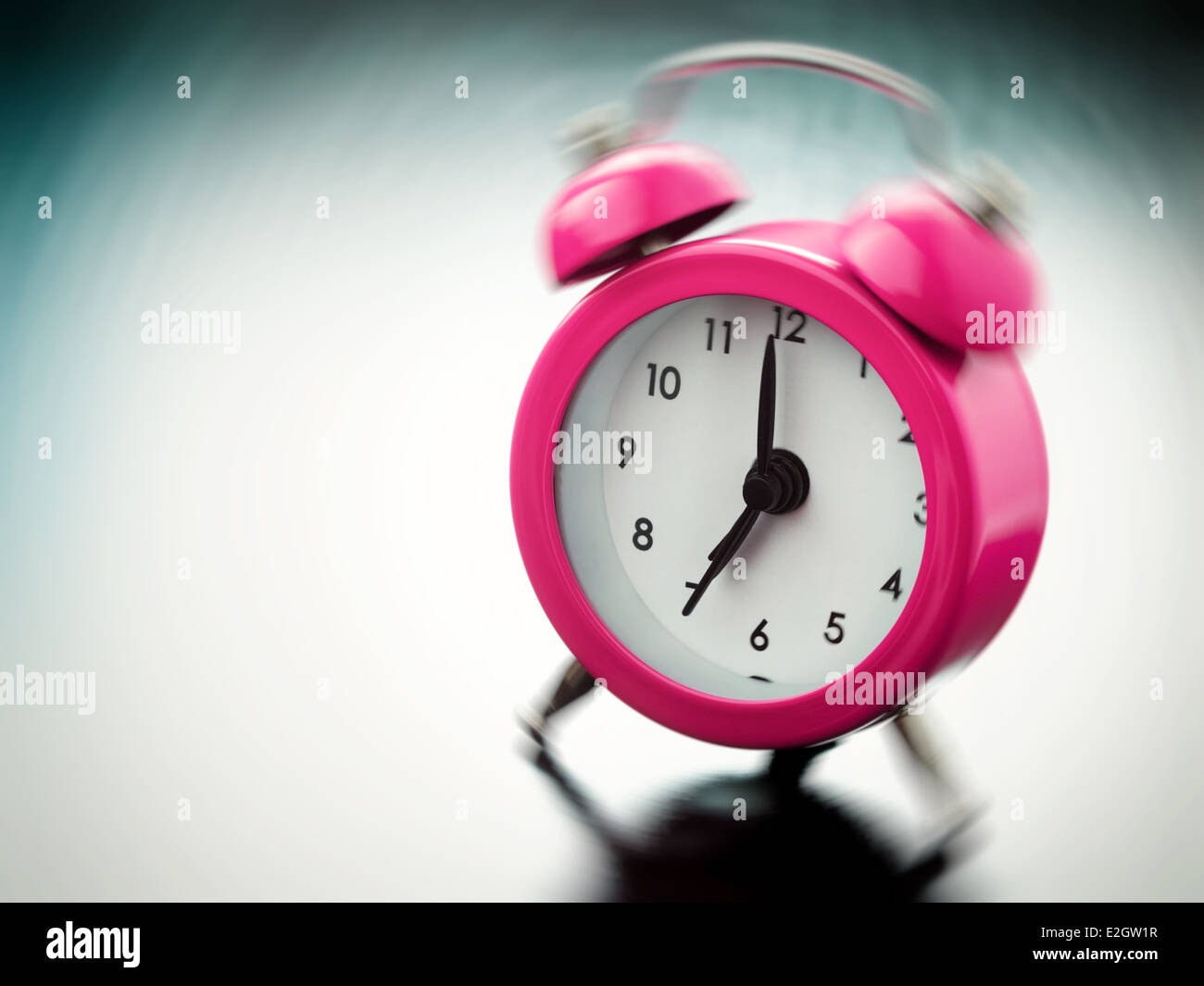 pink Alarm clock ringing on bedside table Stock Photo