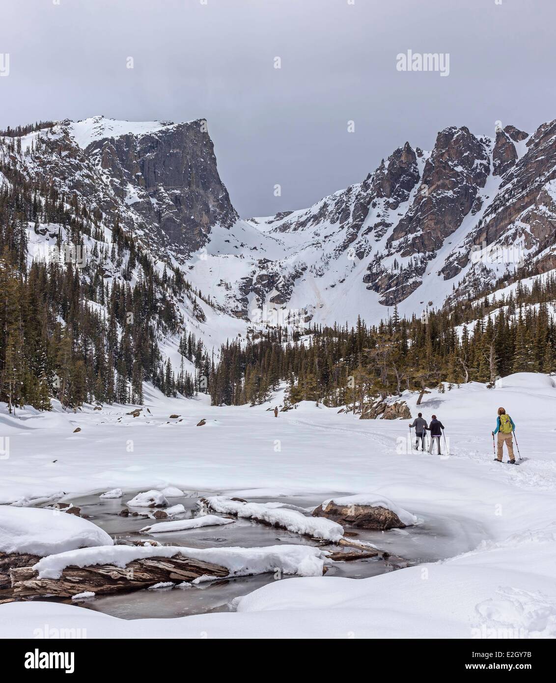 United States Colorado Rocky Mountains Rocky Mountain National Park snowshoers over frozen Dream Lake Hallett Peak on Continental Divide in background Stock Photo