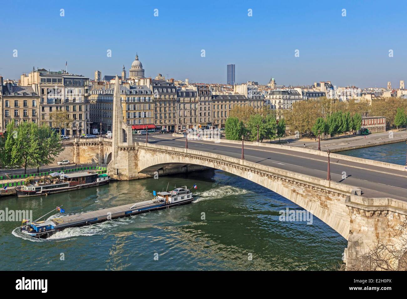 France Paris banks of Seine river listed as World Heritage by UNESCO river Seine and a boat with Pont de Tournelle between Ile Saint Louis and left bank La Tour d'Argent restaurant on left and Pantheon in background Stock Photo