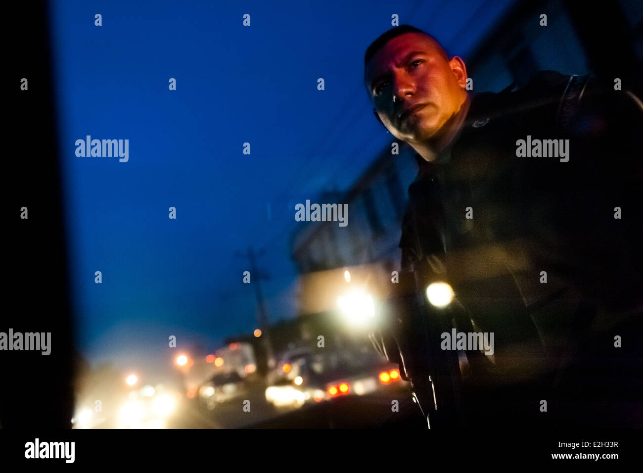 A policeman from the special emergency unit (Halcones) watches the street from a driving vehicle in San Salvador, El Salvador. Stock Photo