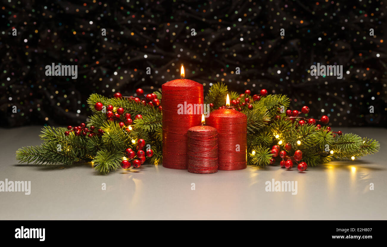 Three red Candles with Christmas tree branches and red berries decorated Stock Photo