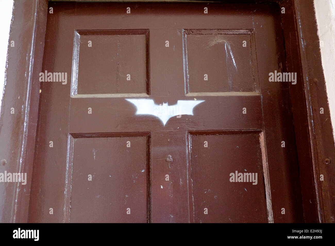 white Batman logo on a brown door. Wollaton Hall Nottingham England UK.(location for the Batman film 'Dark Night Rises' Stock Photo