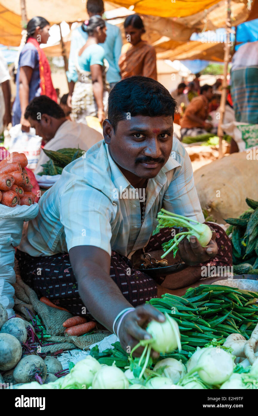 Cheerful vendor promoting kohlrabi, Indian market, Chinnamanur, Tamil Nadu, India Stock Photo