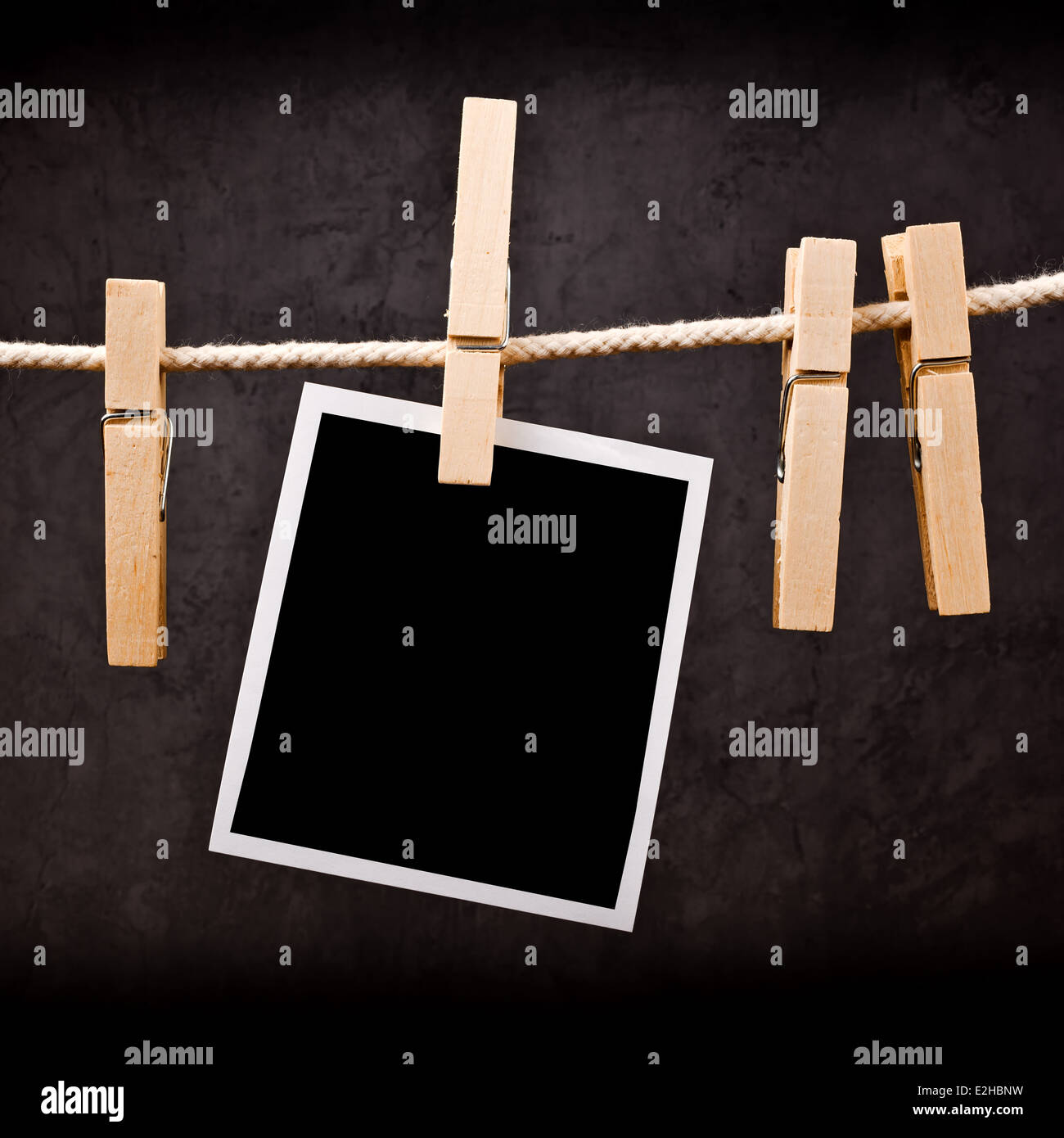 Photography paper with instant photo frame attached to rope with clothes pins. Copy space for your image. Stock Photo