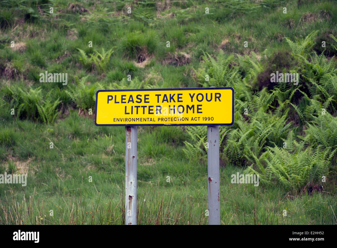Yellow sign in the countryside asking people to their litter home. Stock Photo