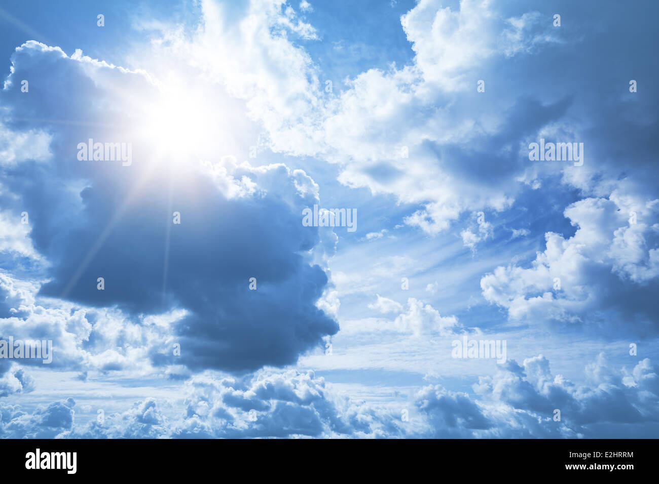 Bright blue sky background with white clouds and shining sun Stock Photo