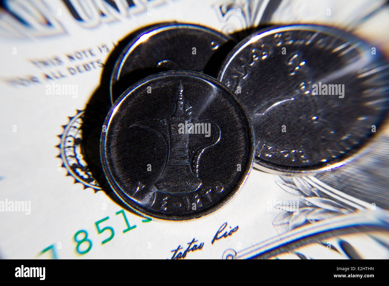 United Arab Emirates Diram coins sat on top of American one dollar bill Stock Photo