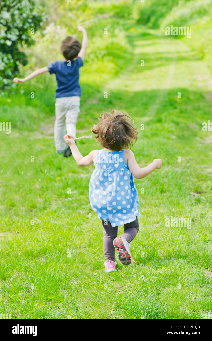 Children running on path through countryside Stock Photo