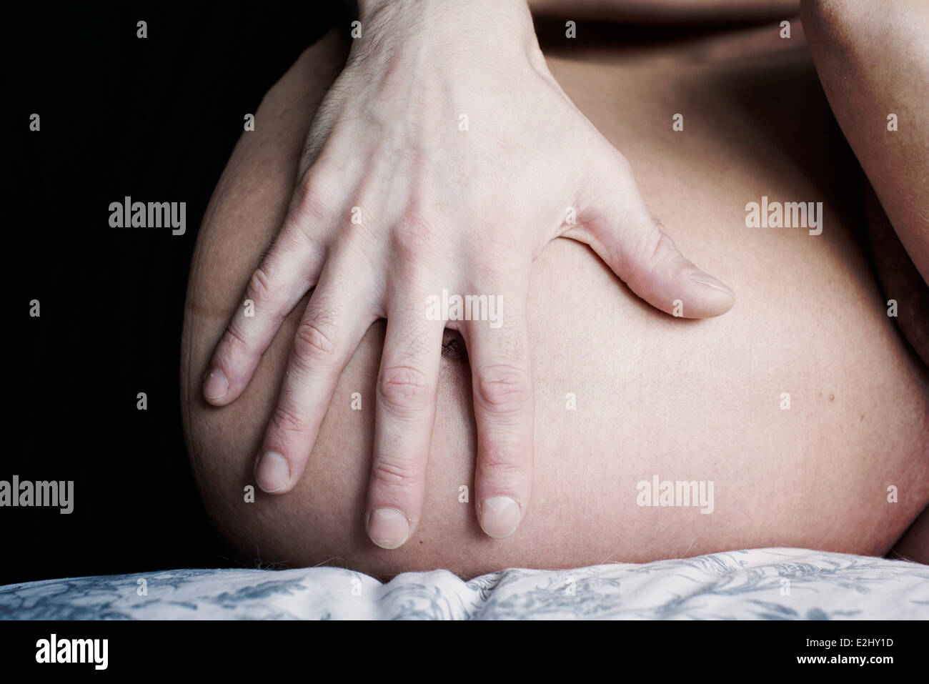 Woman's hand on pregnant stomach, close-up Stock Photo