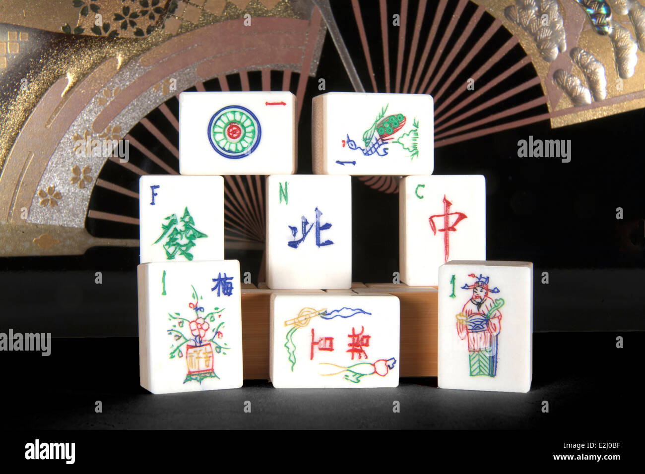 Fish bone maj jong tiles in traditional style in front of decorative fans Stock Photo