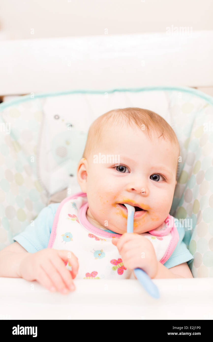 Little girl eating baby food in high chair Stock Photo Alamy