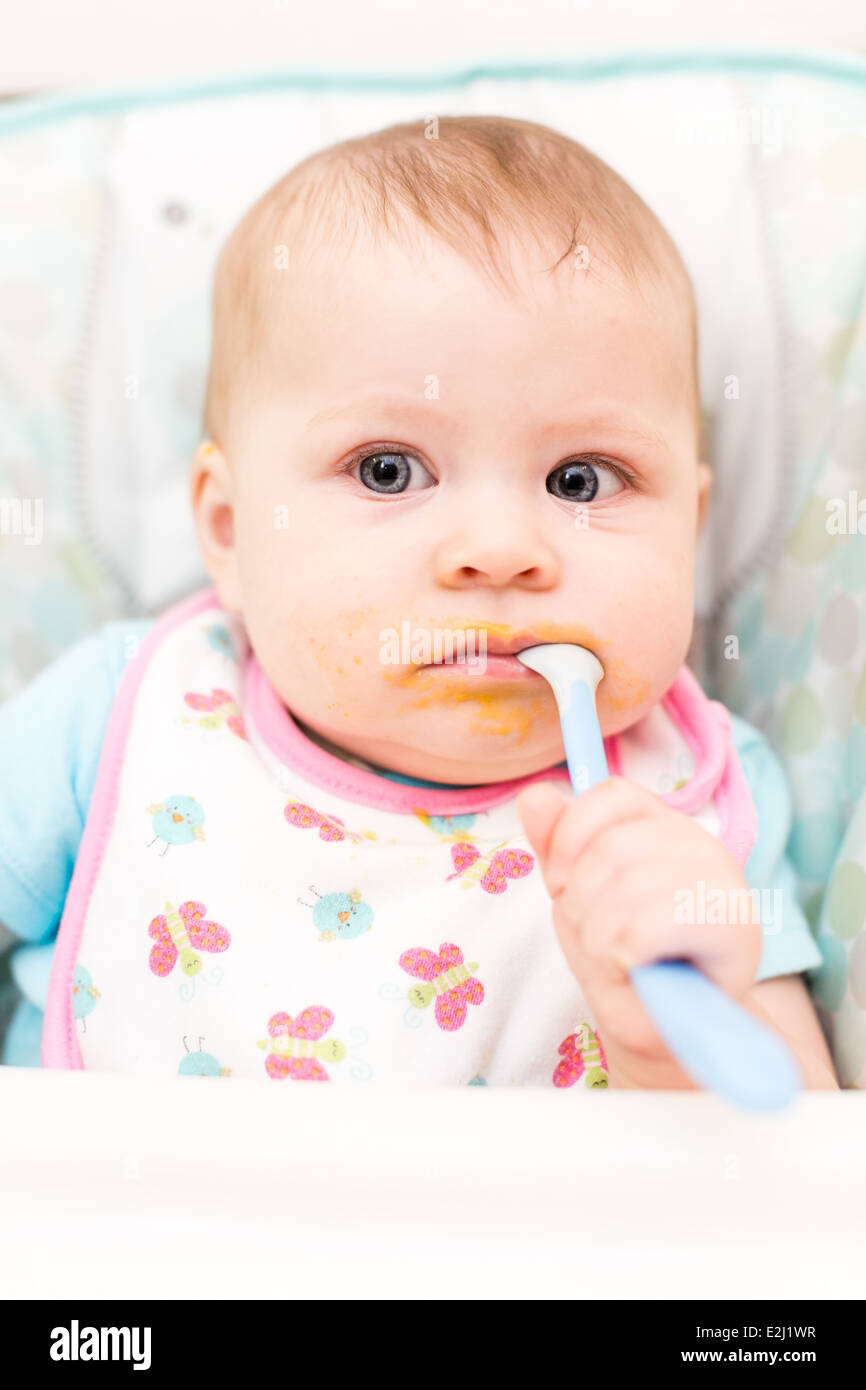Little girl eating baby food in high chair Stock Photo Alamy